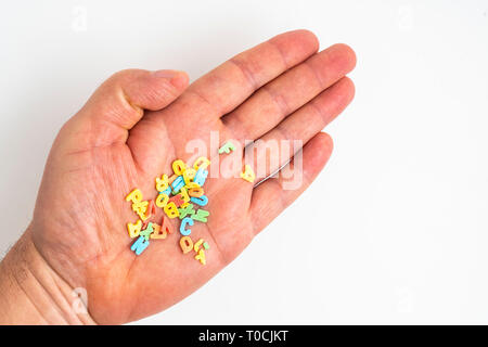 the colorful letters scattered in the palm of a hand Stock Photo