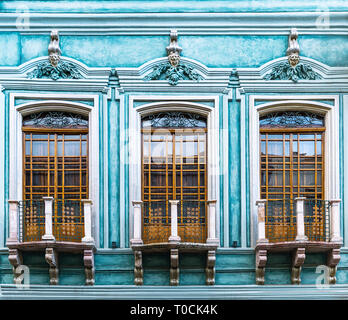The intricacy of a turquoise colonial style facade with balcony in the historic city center of Cuenca, Ecuador, South America. Stock Photo
