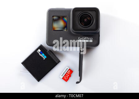 Detail of the correct way to insert the battery and the memory card into the new GoPro Hero 7 Black isolated on white. Stock Photo