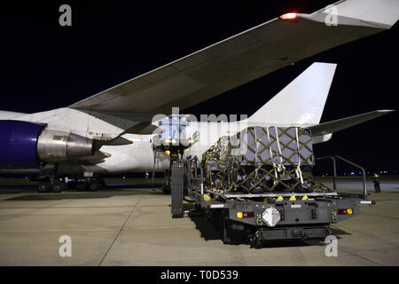A team of guardsmen line up a “K loader” vehicle when a Boing 747 aircraft arrived to receive cargo at the 171st Air Refueling Wing, a Pennsylvania Air National Guard Station near Pittsburgh Pa. for delivery to Guam, March 11, 2019. Loading a civilian Boing 747 presented a new challenge to guardsmen at the 171st because it is the first time they loaded a civilian 747 at the unit. (U.S. Air National Guard Photo by Senior Master Sgt. Shawn Monk) Stock Photo