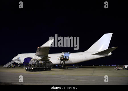 A team of Air National Guardsmen lines up a “K loader” vehicle when a Boing 747 aircraft arrives to receive cargo at the 171st Air Refueling Wing, a Pennsylvania Air National Guard Station near Pittsburgh Pa. for delivery to Guam, March 11, 2019. Loading a civilian Boing 747 presented a new challenge to guardsmen at the 171st because it is the first time they loaded a civilian 747 at the unit. (U.S. Air National Guard Photo by Senior Master Sgt. Shawn Monk) Stock Photo