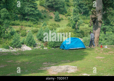 A person near his camping tent at a camping site in Pahalgam in Kashmir Stock Photo