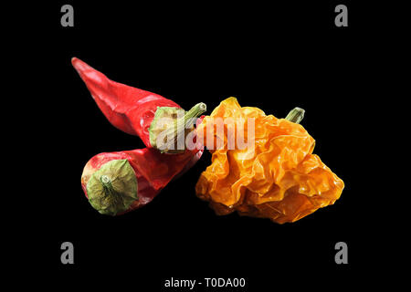 Red chili peppers and yellow habanero on black background Stock Photo