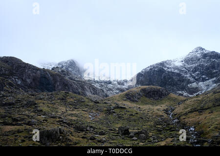 The peaks of Snowdonia, viewed from the Llanberis pass in North Wales are covered in snow. Stock Photo