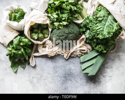 Healthy green vegan ingredients for cooking. Various clean green vegetables and herbs in textile bags. Products from the market without plastic. Zero  Stock Photo