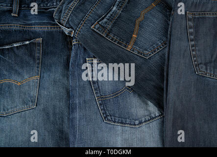 Lots of blue classic jeans stacked chaotically, back pocket Stock Photo