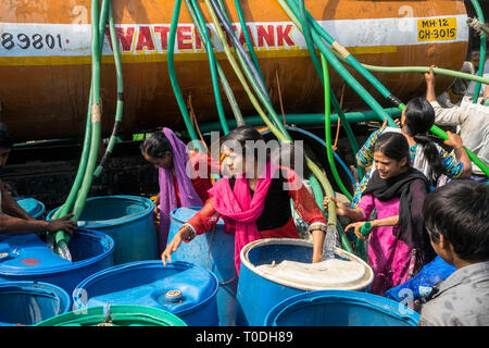 People filling water in plastic drums from water tanker truck, Bhiwandi, Maharashtra, India, Indian water shortage Stock Photo