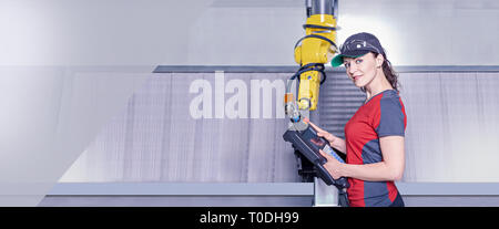 A young female technician while machine constructing in a manufacturing plant Stock Photo