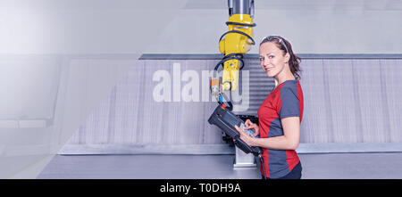 A young female technician while machine constructing in a manufacturing plant Stock Photo