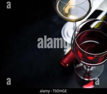 Glass of red and white wine on black background. Wine list design menu with copyspace. Alcohol beverage card backdrop. Stock Photo
