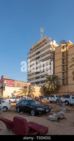 Khartoum, Sudan, February 5., 2019: Street in the center of Khartoum with the Chinese Plaza Hotel in the background and an open garage in the foregrou Stock Photo