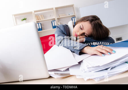 Beautiful female employee unhappy with excessive work Stock Photo
