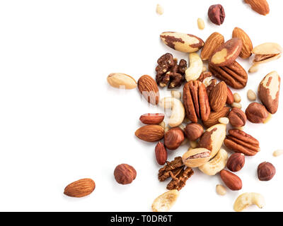 Background of nuts - pecan, macadamia, brazil nut, walnut, almonds, hazelnuts, pistachios, cashews, peanuts, pine nuts.Copy space. Isolated one edge on white with clipping path. Top view or flat lay Stock Photo