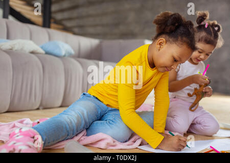 Attentive brunette child drawing picture for mom Stock Photo