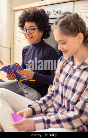 Joyful international boy laughing at funny joke Stock Photo