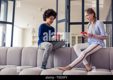 Positive delighted children spending free time while playing Stock Photo