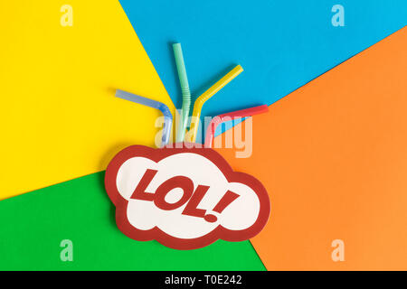 Lol text in speech bubble with drinking straws against multicolored background abstract. Stock Photo