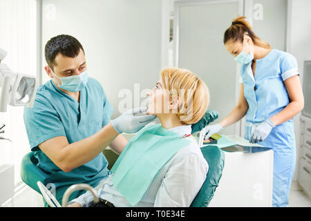 Dentist examines the teeth of the patient girl Stock Photo