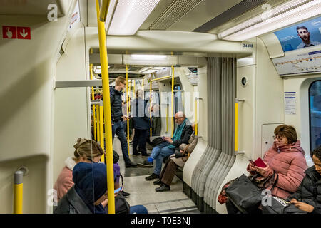 People sitting and standing on a on a S7 stock District Line train on The London Underground, London, UK Stock Photo