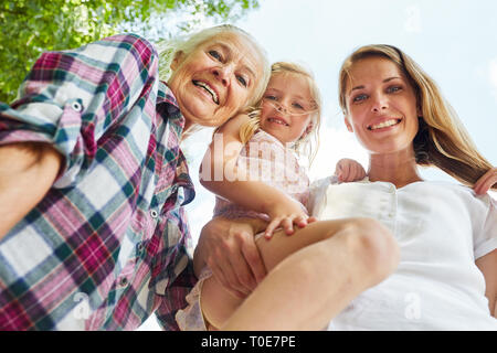 Happy family with women in three generations as extended family in summer Stock Photo