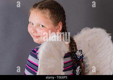 Strong stout smiling angel girl with wings. Stock Photo