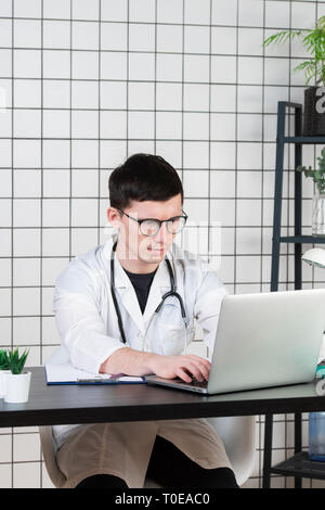 Young handsome doctor working night time at the hospital Stock Photo