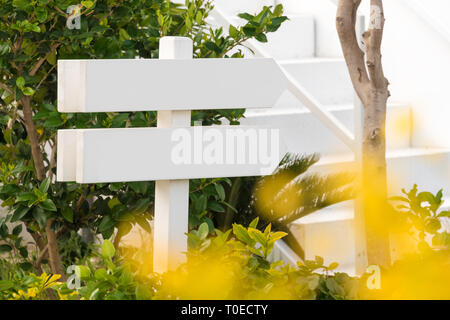 Empty wooden sign with two arrows in the garden Stock Photo