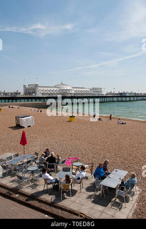 Holidaymakers enjoying refreshments sitting outside a cafe on the seafront in Brighton, Sussex, England. Stock Photo