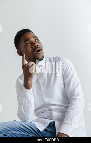 Remember all. Let me think. Doubt concept. Doubtful, thoughtful afro man remembering something. Young emotional man. Human emotions, facial expression concept. Studio. Isolated on trendy green. Front Stock Photo