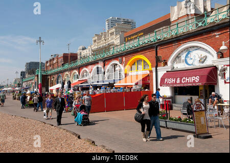 People walking along the promenade on the seafront in Brighton, Sussex, England. Stock Photo