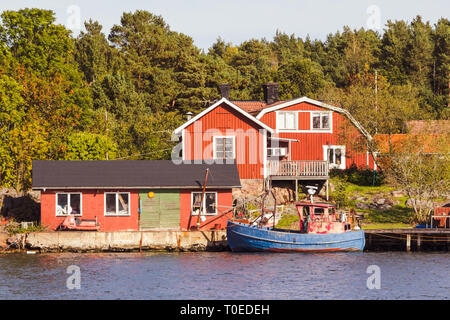 Red cottages and fishing boat in south Sweden Stock Photo