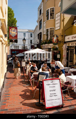 People sitting outside a restaurant in The Lanes area of the seaside town of Brighton, Sussex, England. Stock Photo