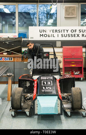 A young international muslim student woking on a racing motorsport cart in the mechanical engineering department of the University of Sussex Stock Photo