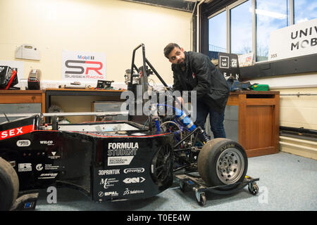 A young international muslim student woking on a racing motorsport cart in the mechanical engineering department of the University of Sussex Stock Photo