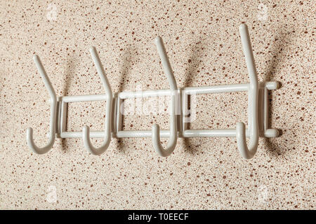 White Clothes hanger on a wall background. Stock Photo