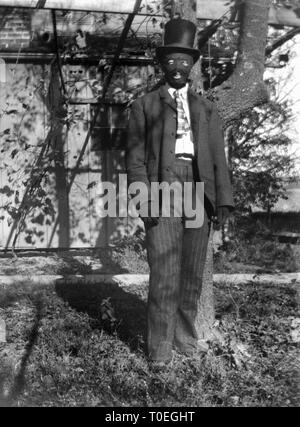 An early 20th century man is all dressed up with a ski mask and gloves on, ca. 1910. Stock Photo