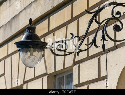 Ornate wrought iron lamp on lamp bracket on the facade of a house in Bath, England Stock Photo