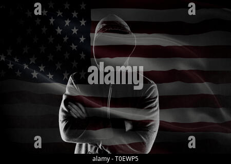 Double exposure of concept of criminal in USA with silhouette of male with crossed hands in hood and flag Stock Photo