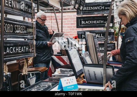 London, UK - March 16. 2019: People looking at posters and home decor on sale at a stall in Greenwich Market, London's only market set within a World  Stock Photo