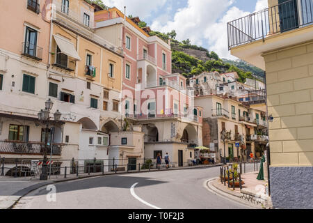 Street scene along the roadway of Amalfi Drive as it passes through a colourful neighbourhood in Minori, Italy Stock Photo