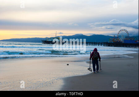 Prospector with metal detector looking for buried treasure at Santa Monica beach Stock Photo
