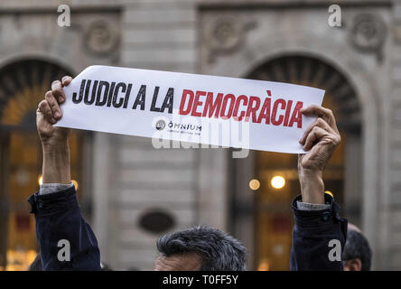 Barcelona, Catalonia, Spain. 19th Mar, 2019. A protester is seen showing a banner saying Judgement for Democracy during the demonstration.Some 150 people have approached the Plaza Sant Jaume in a demonstration to support President Quim Torra's decision to maintain on the balconies of the Catalan institutions independence flags and yellow ties contradicting the Central Electoral Board order which has required the president to withdraw them in a period of 24 hours. Credit: Paco Freire/SOPA Images/ZUMA Wire/Alamy Live News Stock Photo