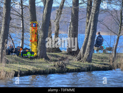 Wolzig, Germany. 20th Mar, 2019. A police officer is sitting on the shore of Lake Wolzig in the district of Dahme-Spreewald. On the same day the search for the missing Rebecca from Berlin was continued. Police divers from Berlin are also on duty. Credit: Patrick Pleul/dpa-Zentralbild/ZB/dpa/Alamy Live News Stock Photo