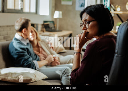 Puzzled doctor with bob haircut thinking about situation in family Stock Photo
