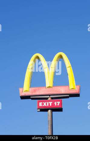 Looking up at McDonalds Golden Arches sign against a clear, deep blue sky Stock Photo