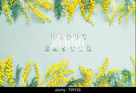 Easter background. Mimosa flowers and festive inscription Happy Easter - festive card Stock Photo