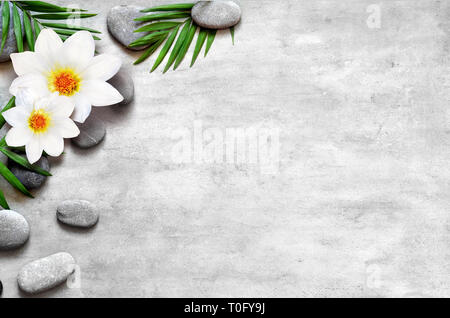 Spa composition of candles, flowers and stones on brown wooden