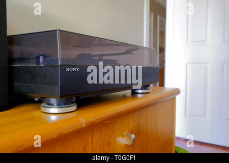 Sony turntable or record player on a wooden dresser; turntable with closed lid; home interior. Stock Photo