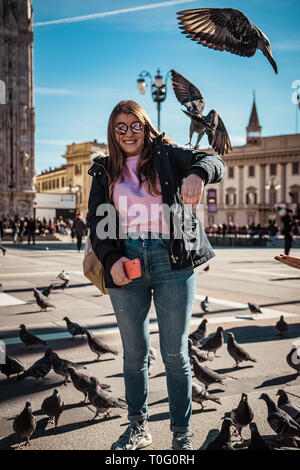 Pigeon flying near people in central square, Milan, Italy