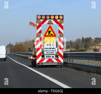 Work in progess in the highway the text meas Reduce speed because there are Men at Work in Italian langauge Stock Photo